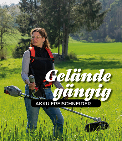 Frau steht  mit Freischneider auf einer großen Wiese